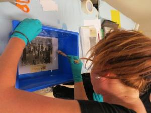 Dr Jo Wills cleaning water damaged photographs.